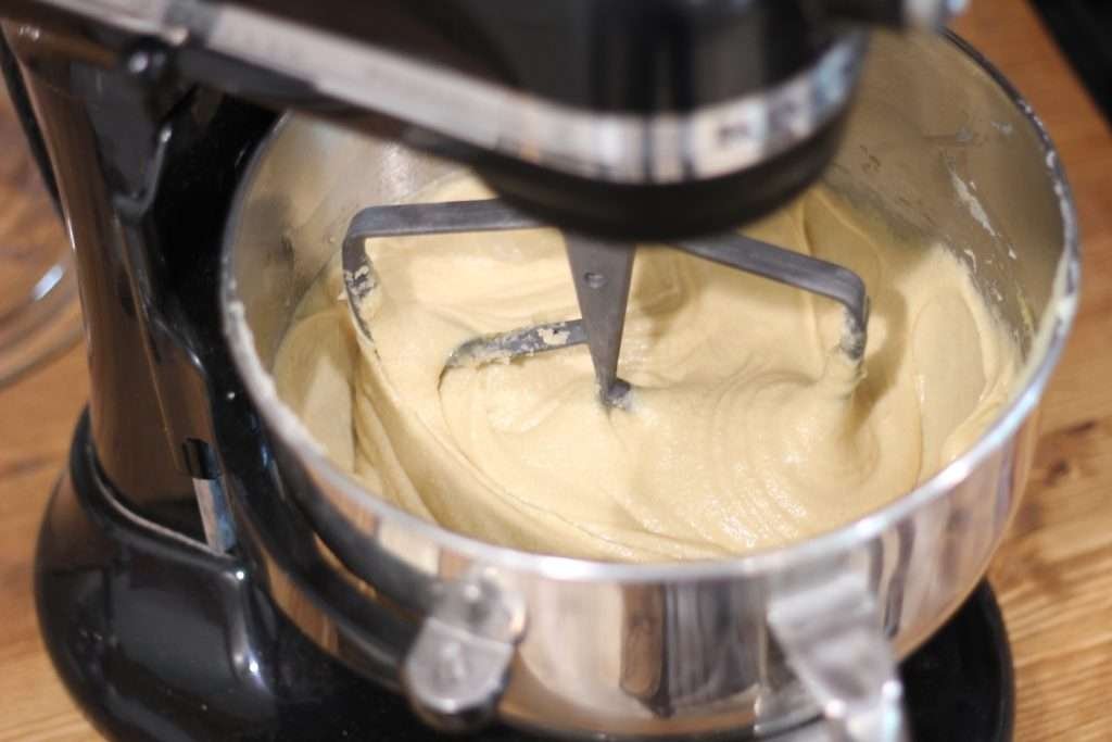 kitchen aide stand mixer with creamed butter, sugar, eggs, and vanilla in mixing bowl. 