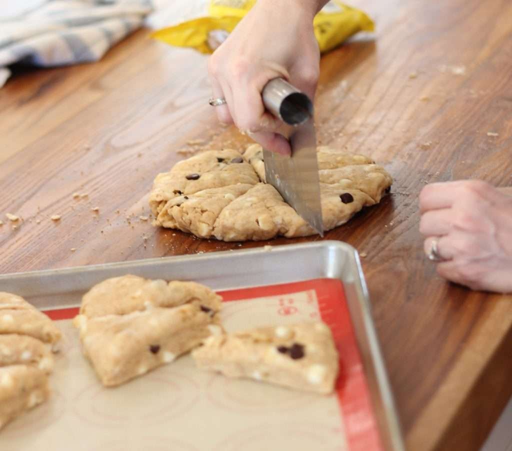 woman cutting sourdough peanut butter chocolate chip scones