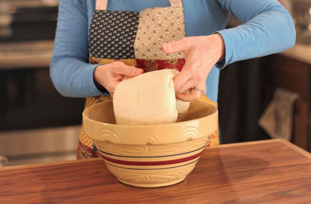 women stretching bread dough