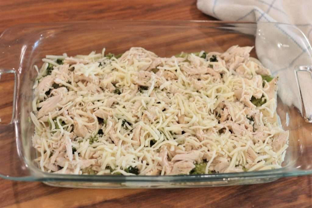 Shredded mozzarella cheese on top of shredded chicken and broccoli