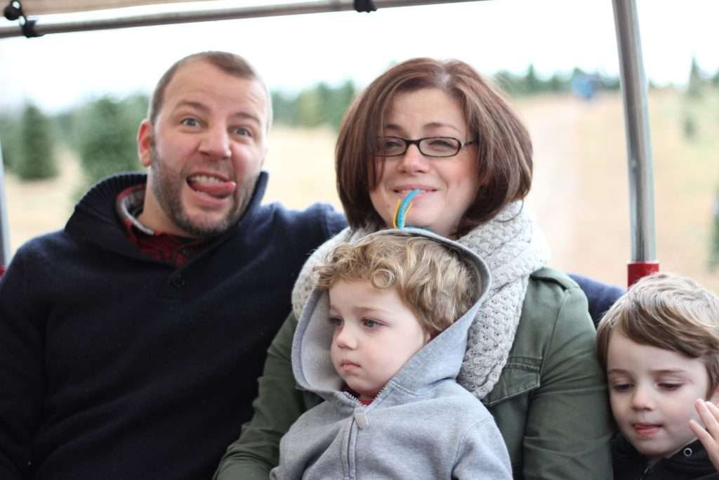 man and woman with two small children on hay ride