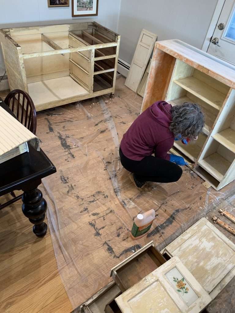 Woman Putting Paint stripper on cabinet