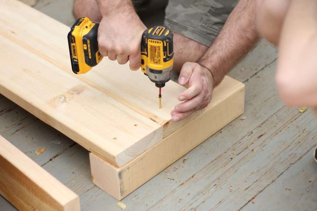 Man using drill to put screws in boards