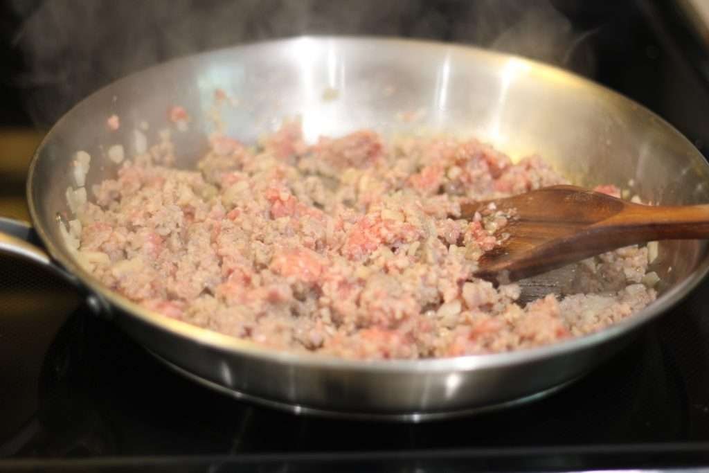 Skillet with sausage and onions browning