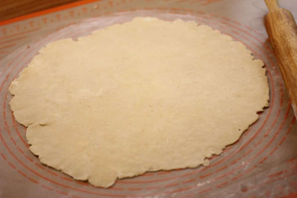 Pie crust dough rolled out on silicone mat