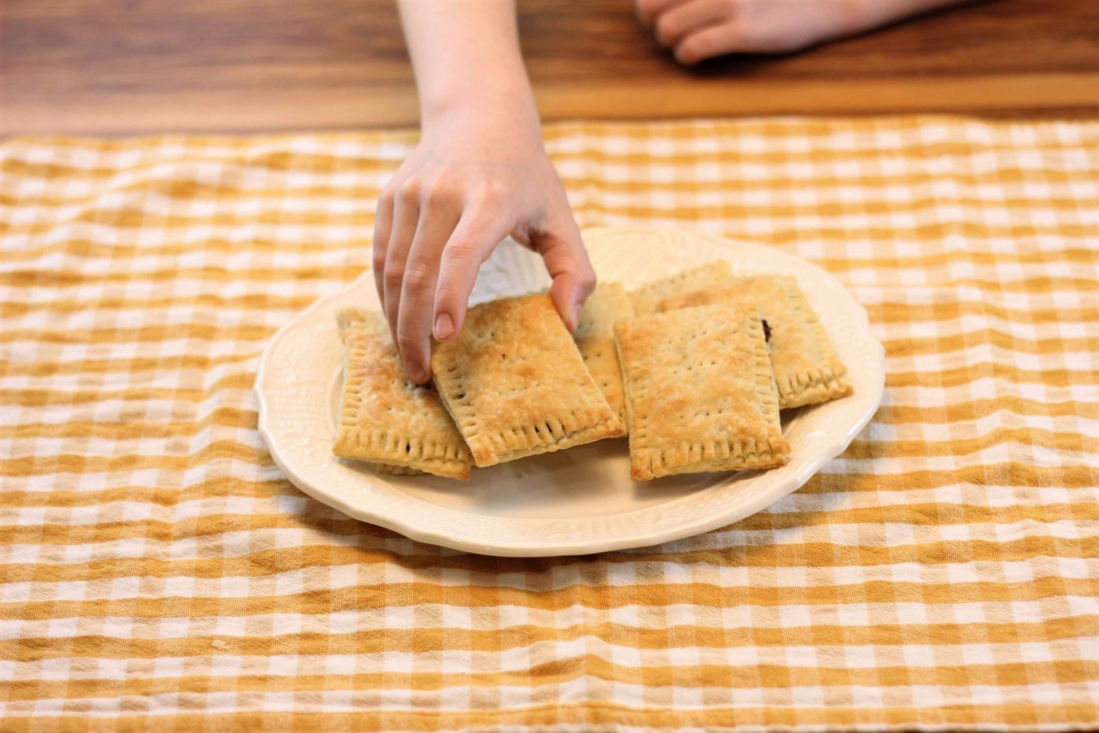 a child taking a homemade pop tart off of a plate.