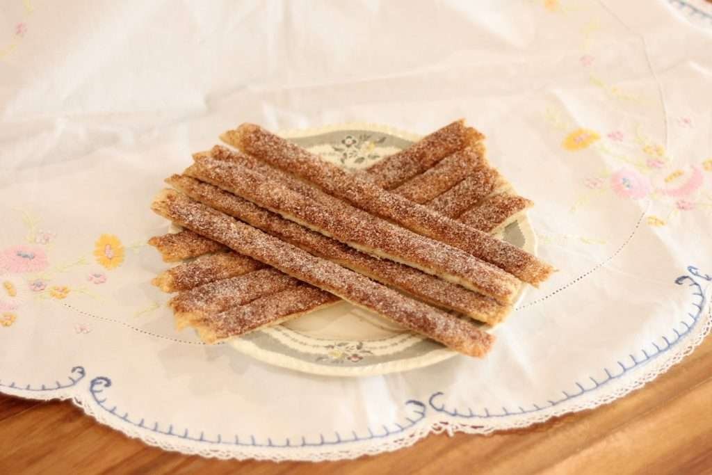 Pastry with cinnamon and sugar cut in sticks on plate