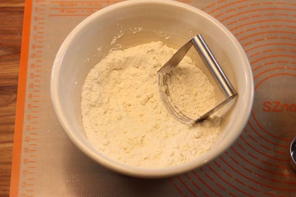 Bowl with flour mixture and butter cut in with pastry cutter. 