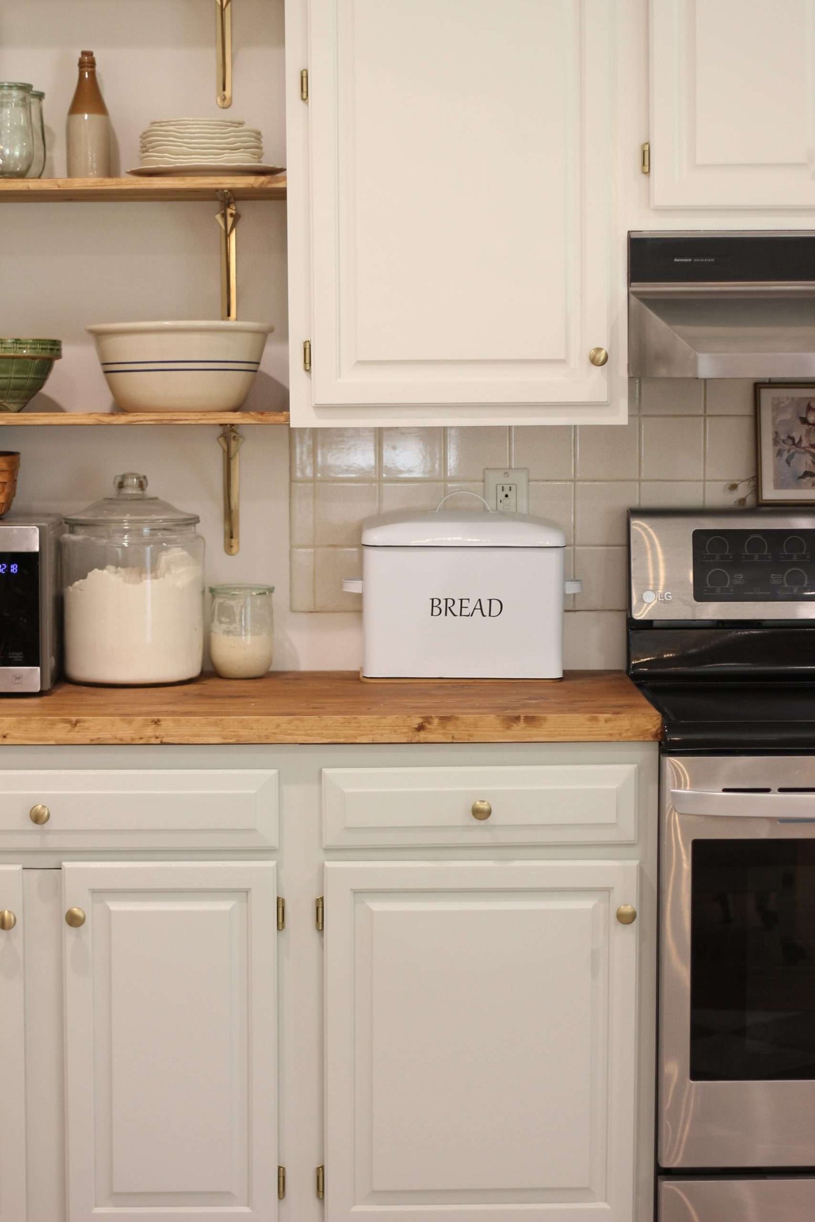 Freshly painted cabinets with a bread box and Flour container on counter.