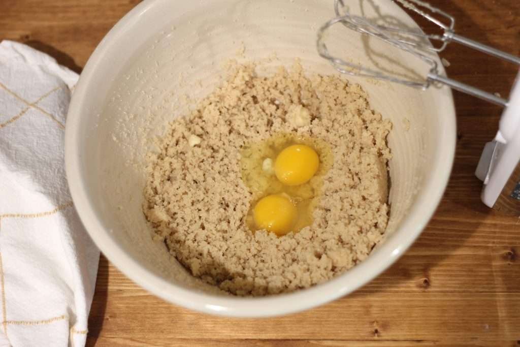 Butter and sugars creamed with eggs in mixing bowl for applesauce spice cake recipe with sourdough discard.