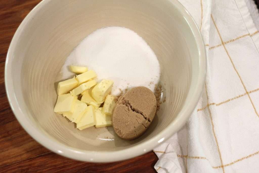 Butter and sugars in a mixing bowl for applesauce spice cake recipe with sourdough discard.